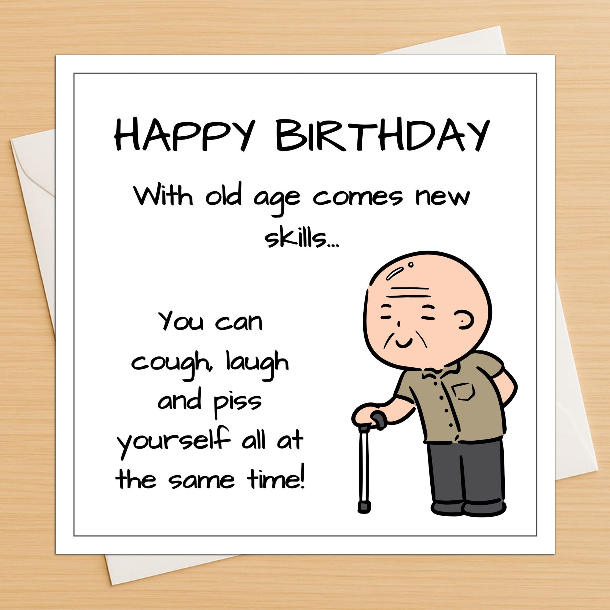 Funny old man birthday card lying flat on a wooden table with white envelope