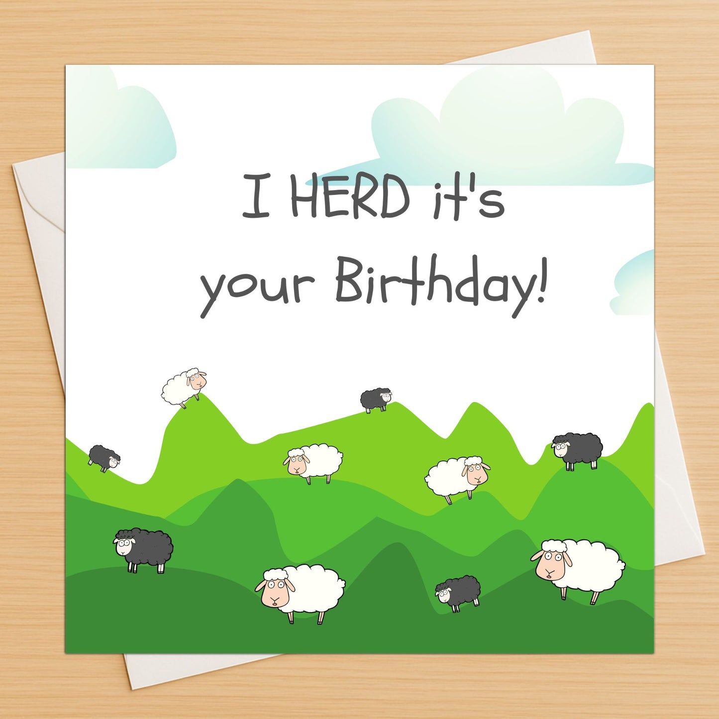 Birthday card with sheep illustration and text 'I HERD it's your Birthday!' on a green landscape.