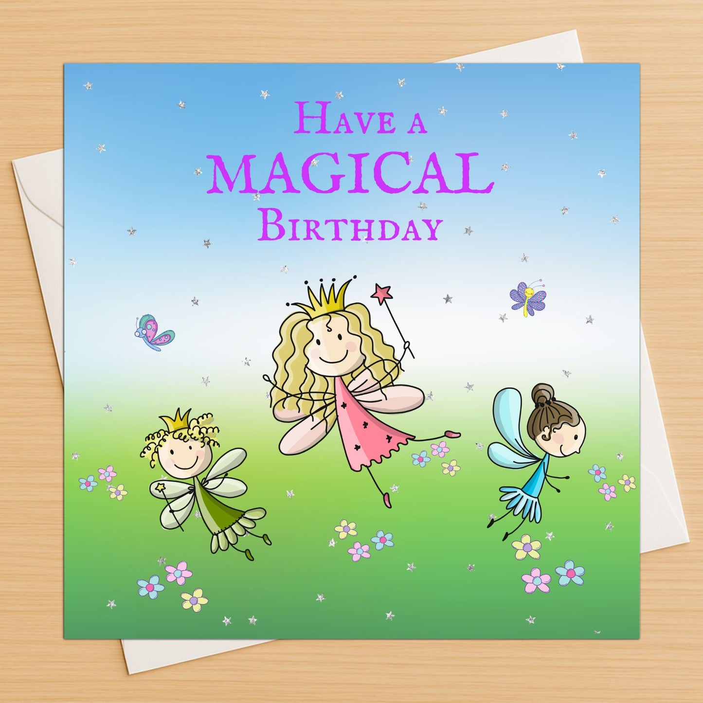 Magical fairy princess birthday card with fairies and crown on wooden table