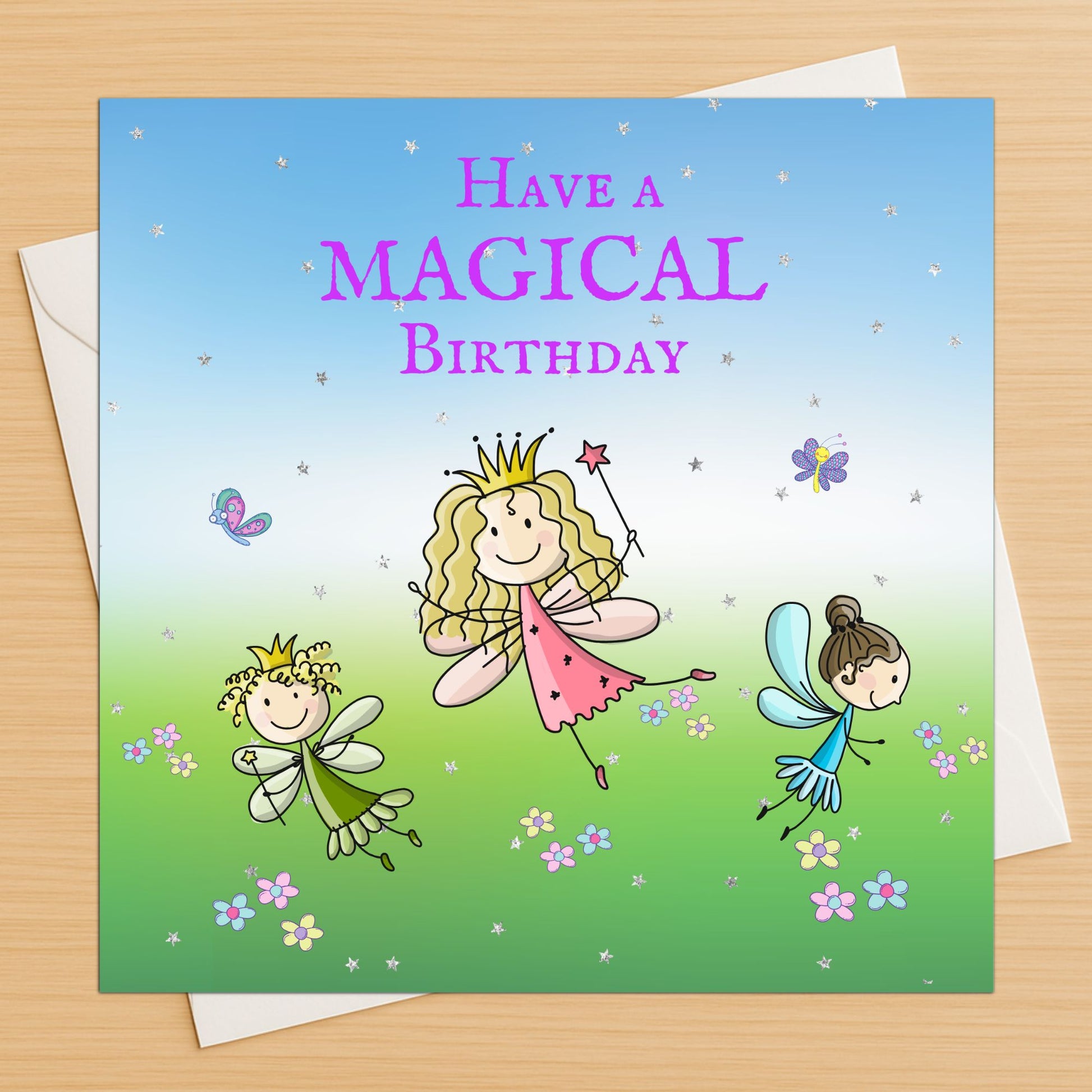 Magical fairy princess birthday card with fairies and crown on wooden table